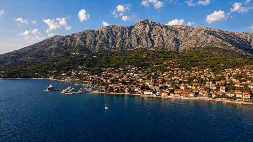 Orebić from the water: the town along the shore, the marina, and Sveti Ilija rising behind it